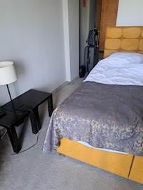 A double bed with a single duvet and no bedside table or access to a light from the bed. Bed too hig for the room.