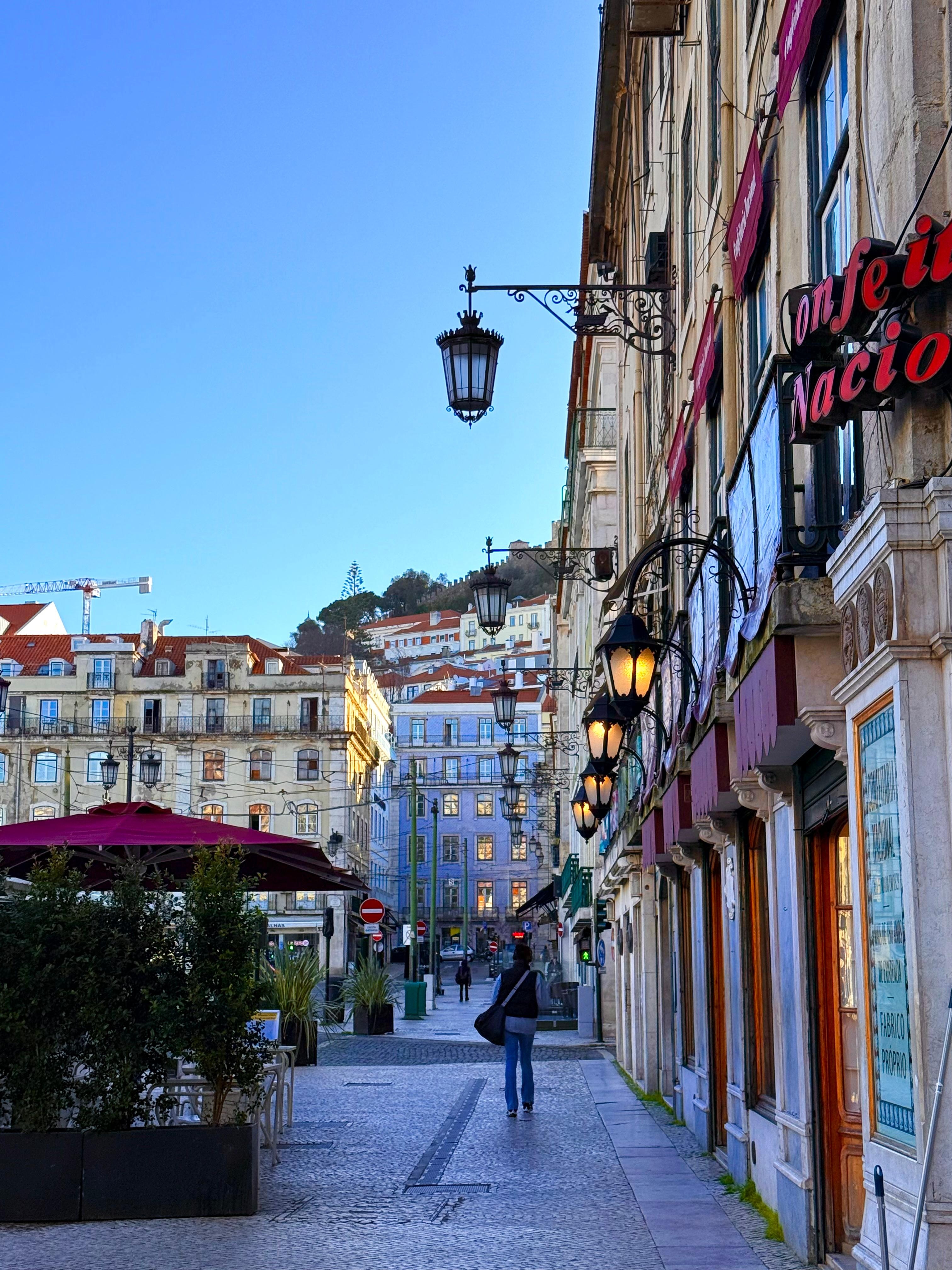 Block away from the hotel — a classic Lisbon city scene with lively streets and historic architecture.