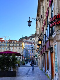 Block away from the hotel — a classic Lisbon city scene with lively streets and historic architecture.