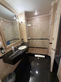 Spacious bathroom with bathtub on the left side.