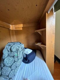 Bottom dorm bunk. Love the shelving. There’s also a lamp on the other side