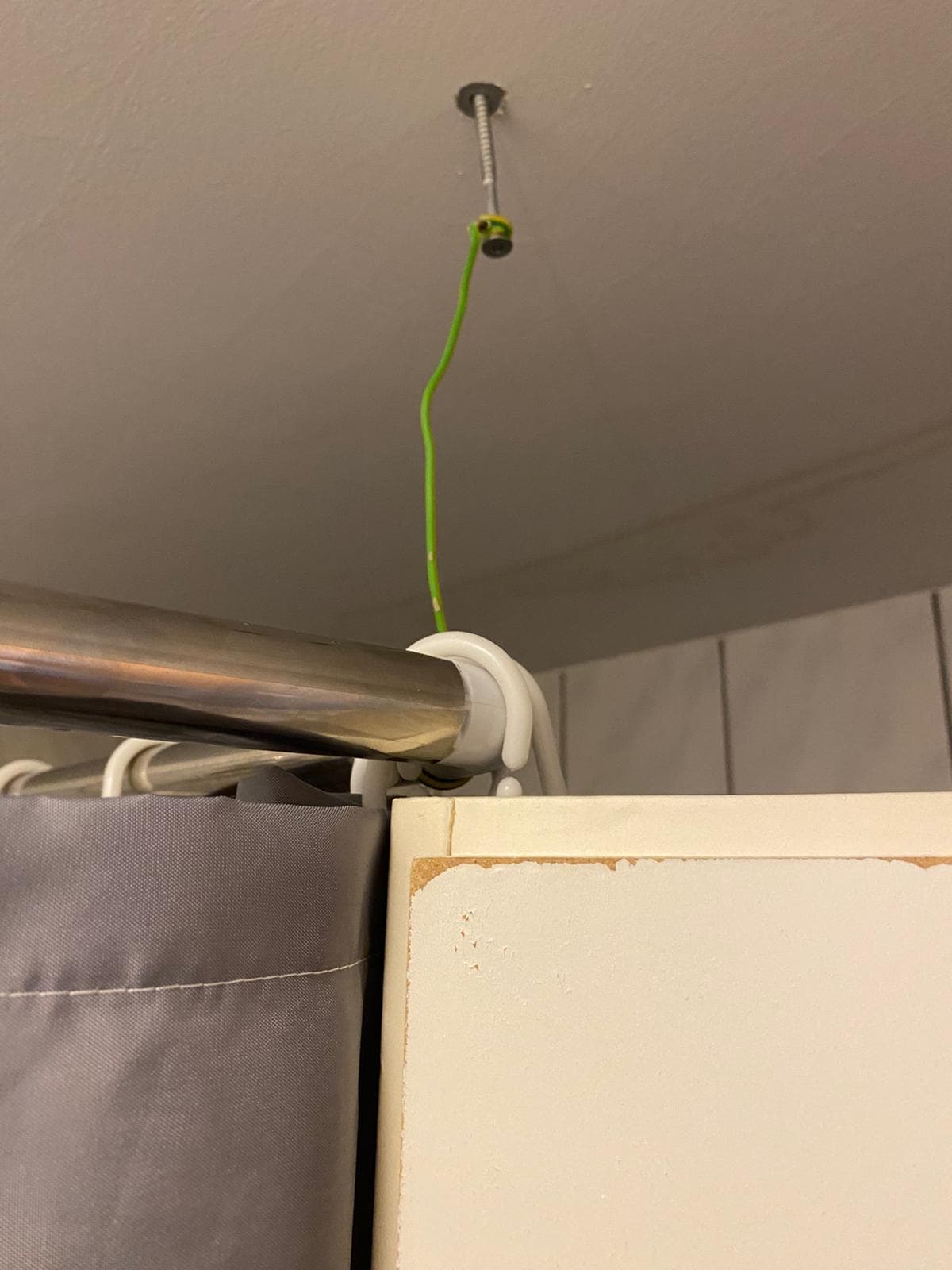 Shower held up with earthing wire and a screw 