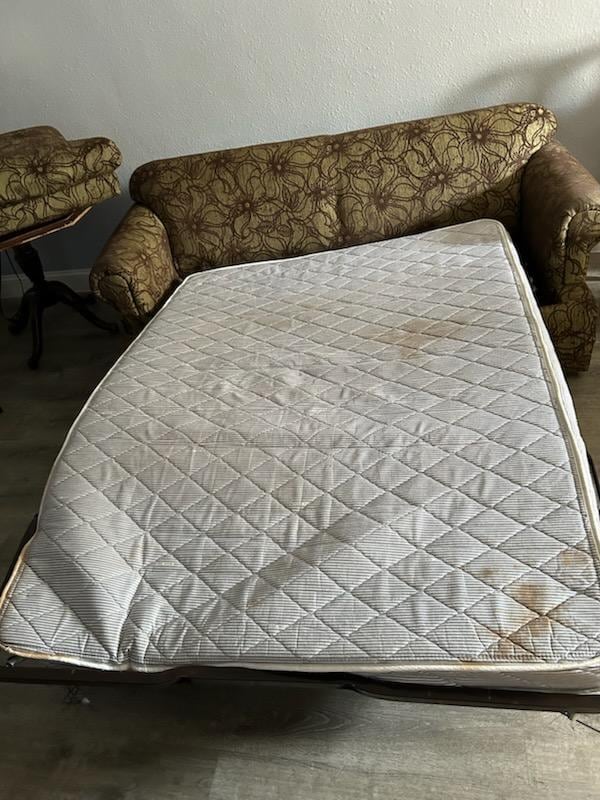 sofa bed pulled out with dirt and grime - and the bed sags because it's broken