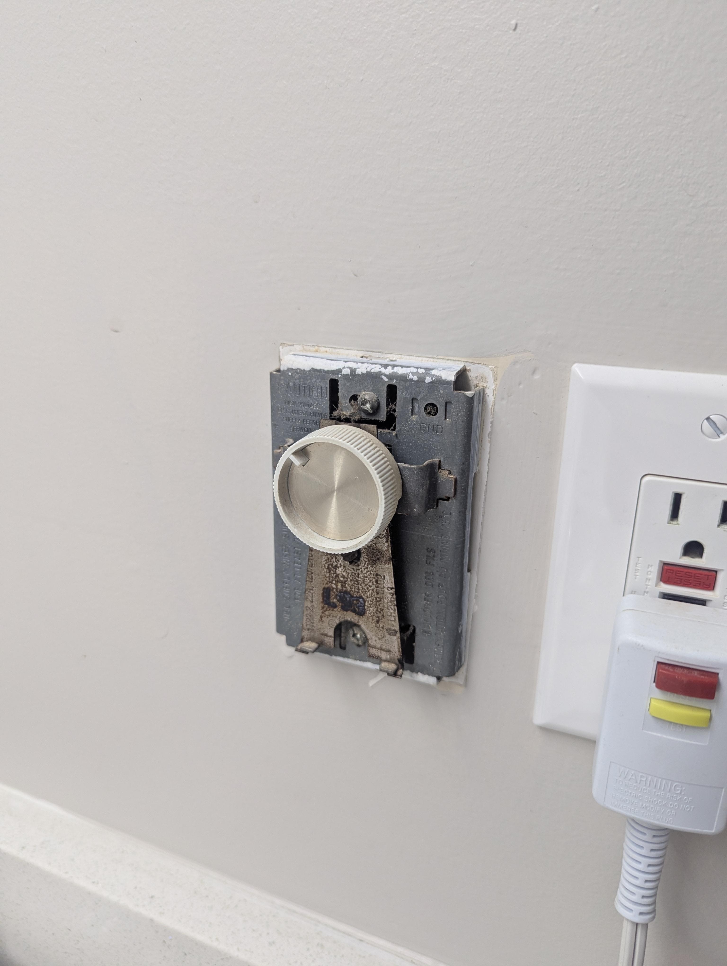 The thermostat for the bathroom missing it's cover 