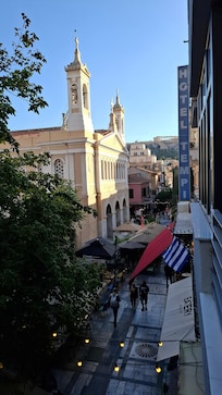 Het uitzicht op het gezellige straatje voorbij het hotel en de Akropolis op de achtergrond
