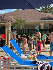 Kids dancing with a poolside DJ.