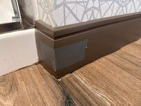 Outside shower corner which was leaking water. Moldings taped together.