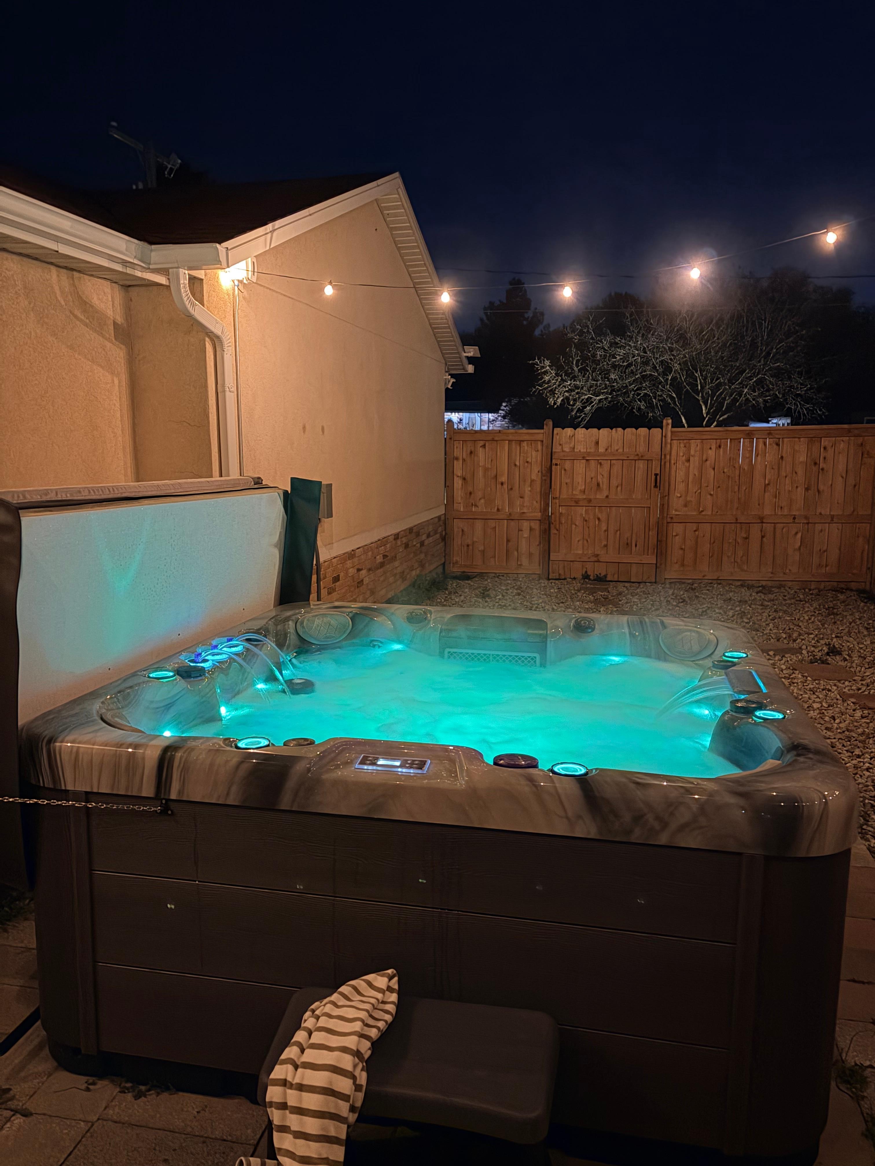 Hot tub at night with various lights in the tub - note the little water features on the opposite ends. Great jets too. 