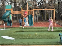 Putting green and playground enjoyed by kids