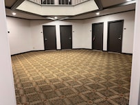 Faded carpet, stark white walls, gray metal doors, akin to a prison