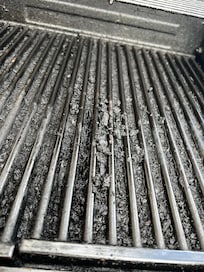 Used a table knife to scrape off some charred food/grease in grates to see how much buildup over grate holes.