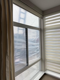 Contractors ladder out Living Room window. Plastic sheeting over windows.