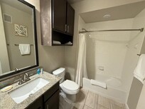 Guest bathroom with tub (cleaners left some towels on the floor)