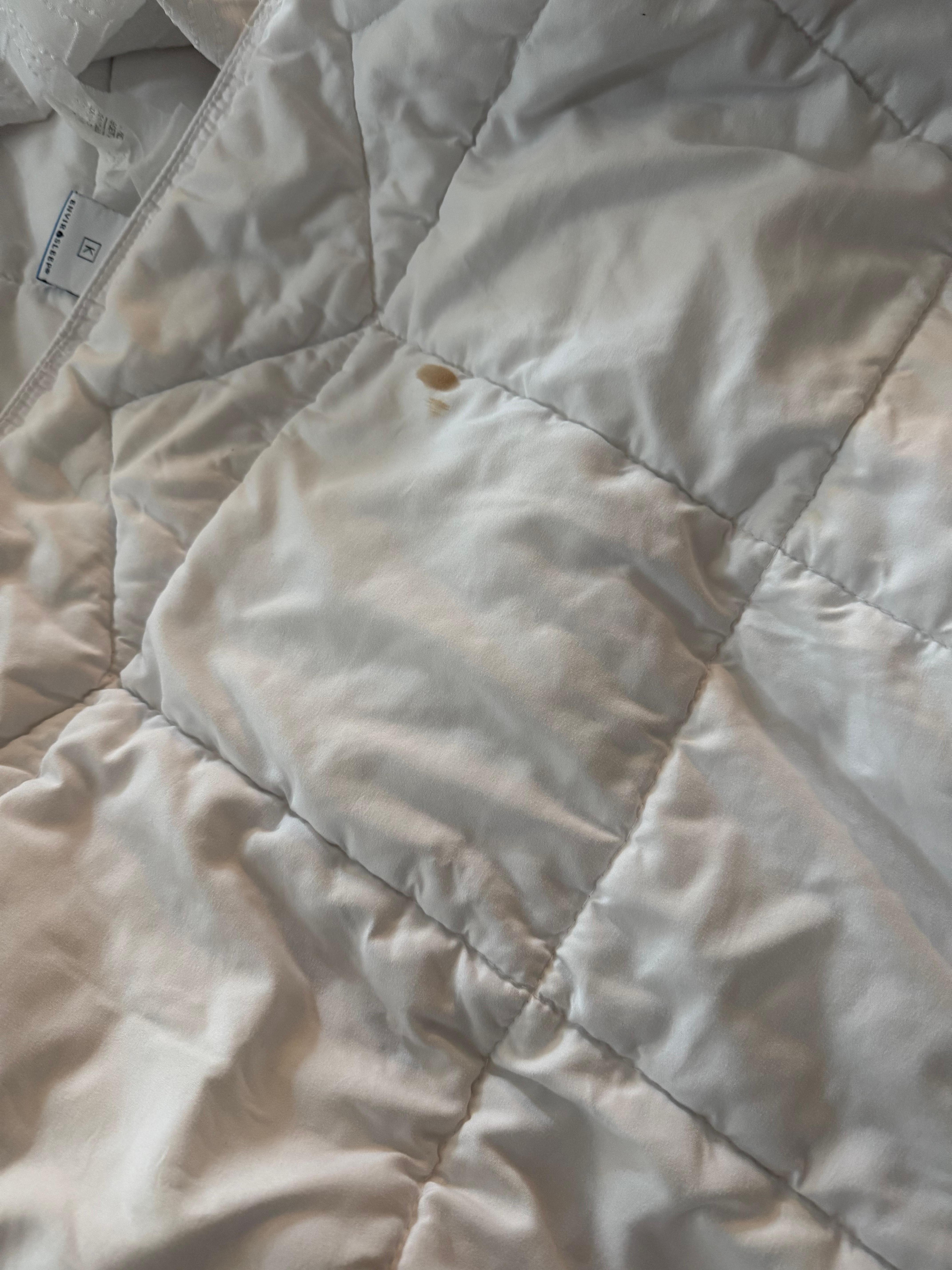 Stain on quilt hidden by turned over sheet