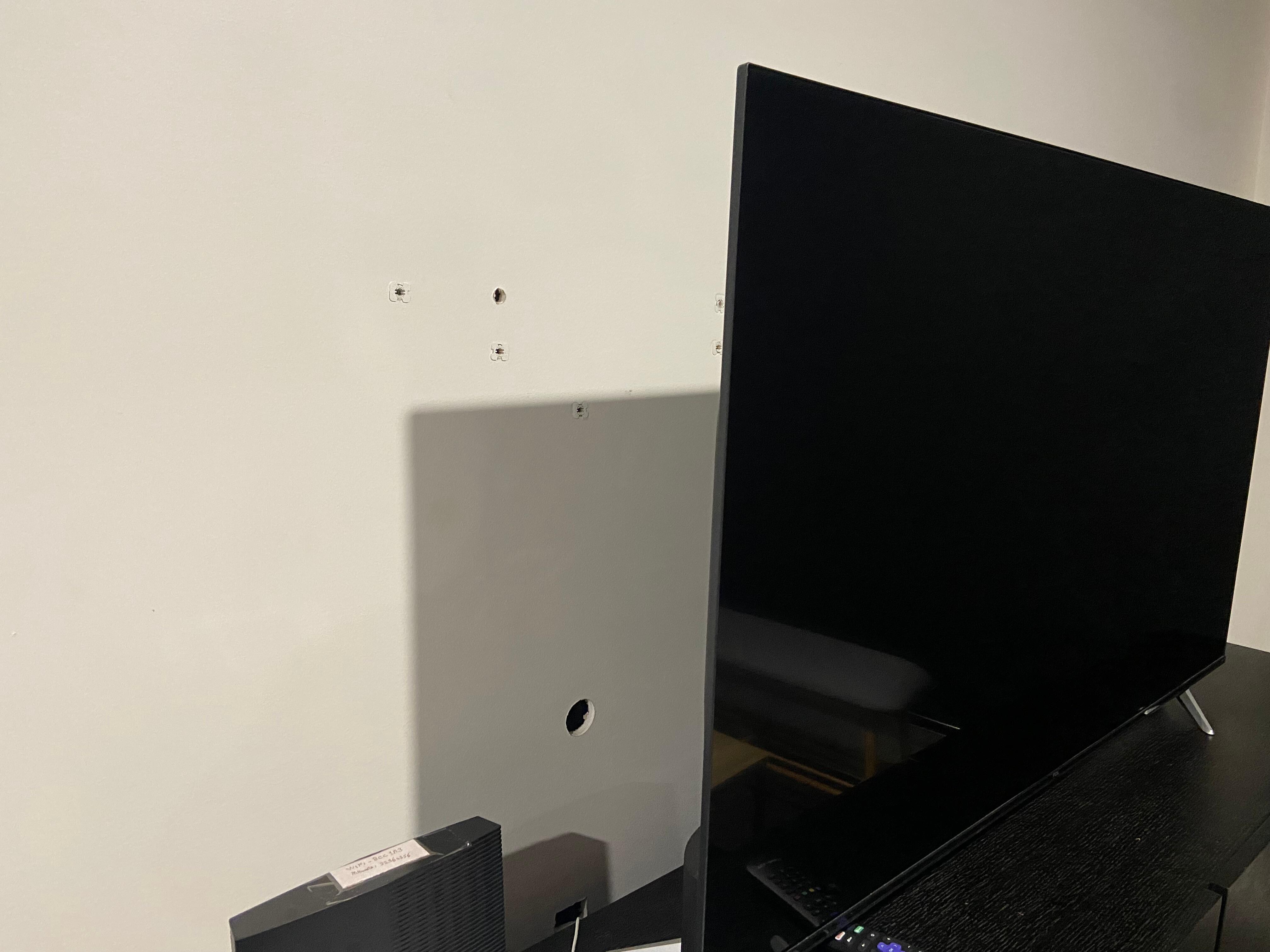 Holes in wall behind TV