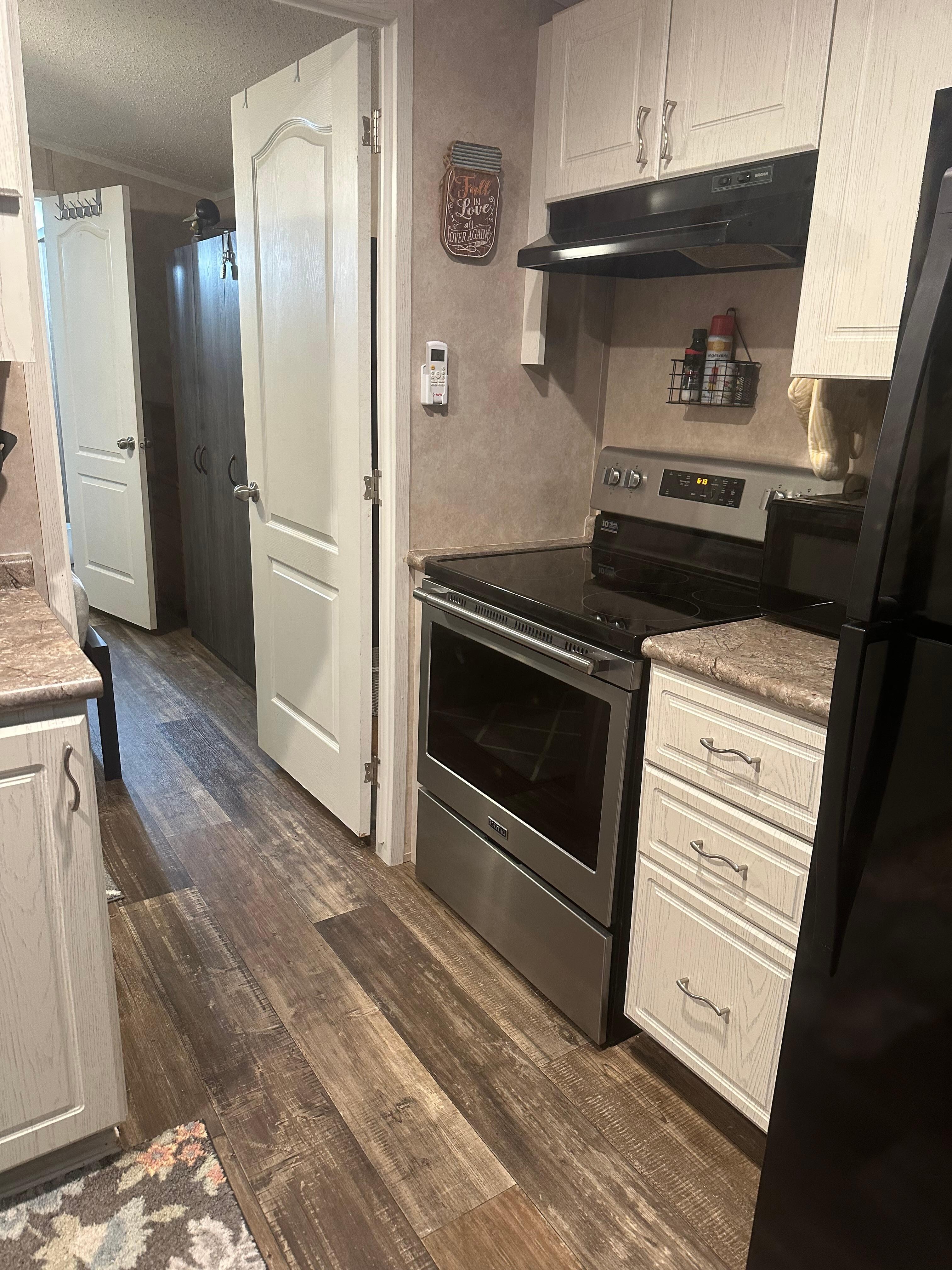 Kitchen with stove, microwave and refrigerator.