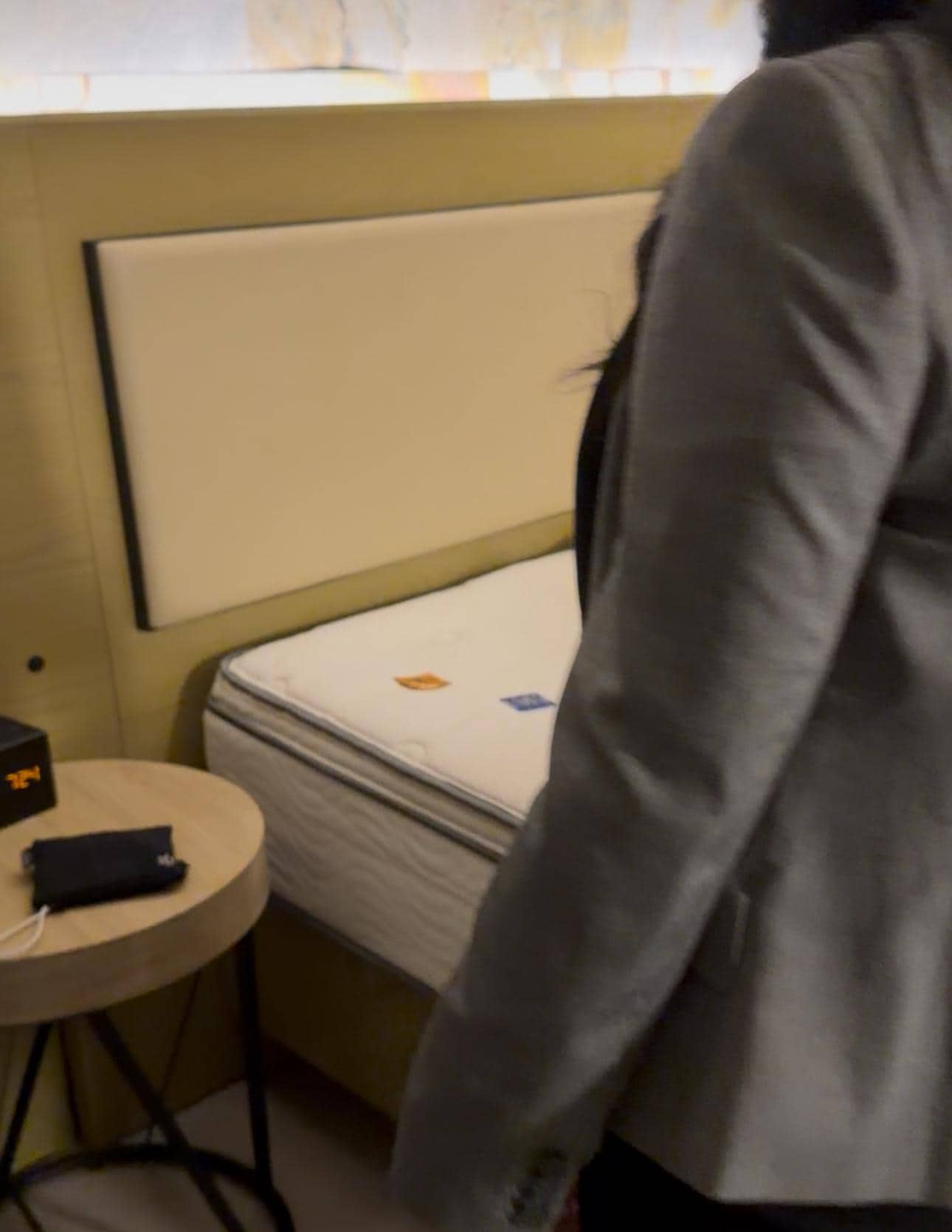 The manager of the   Hotel in front of the bed