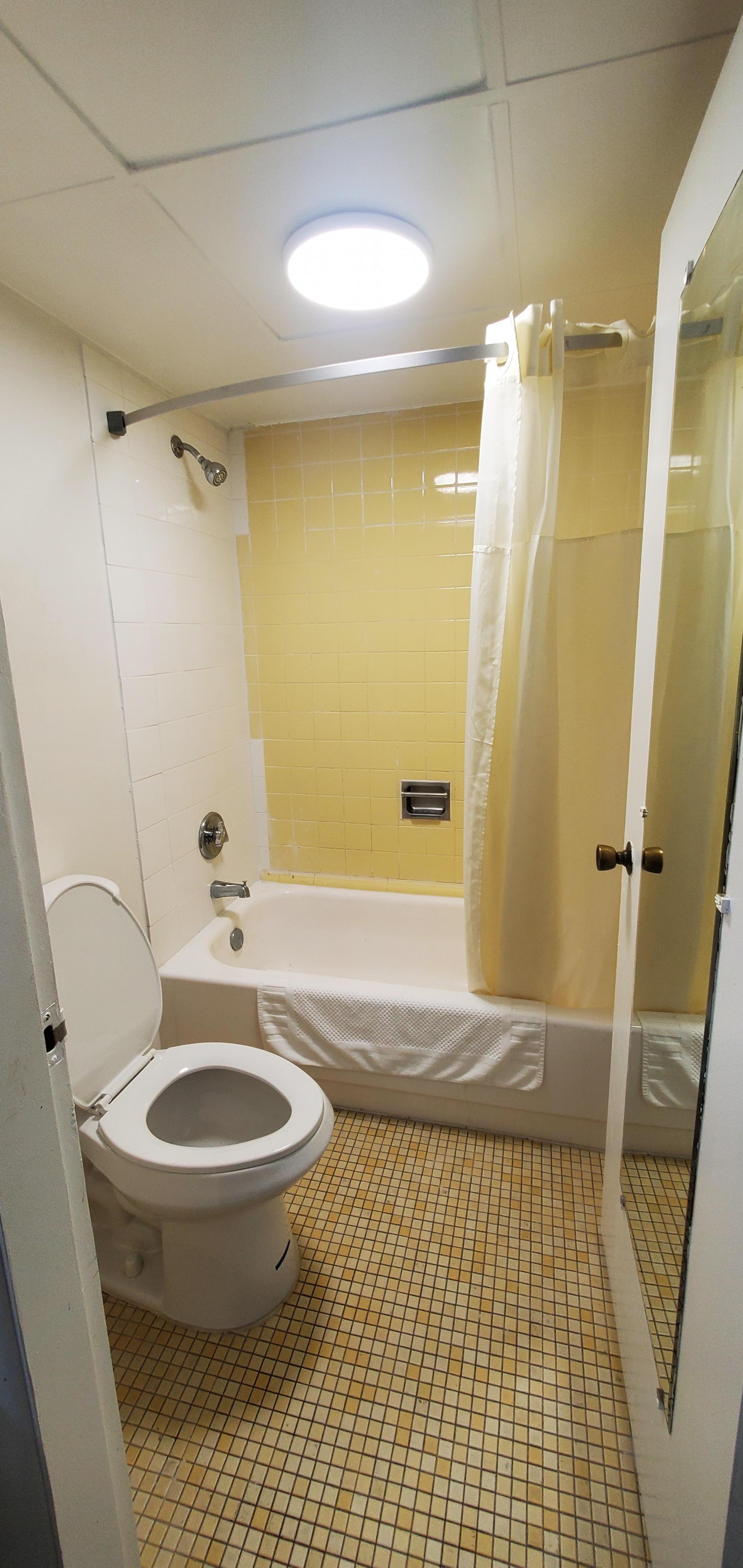 Outside bathroom. Mirror not clear. Brown smudges on wall.
