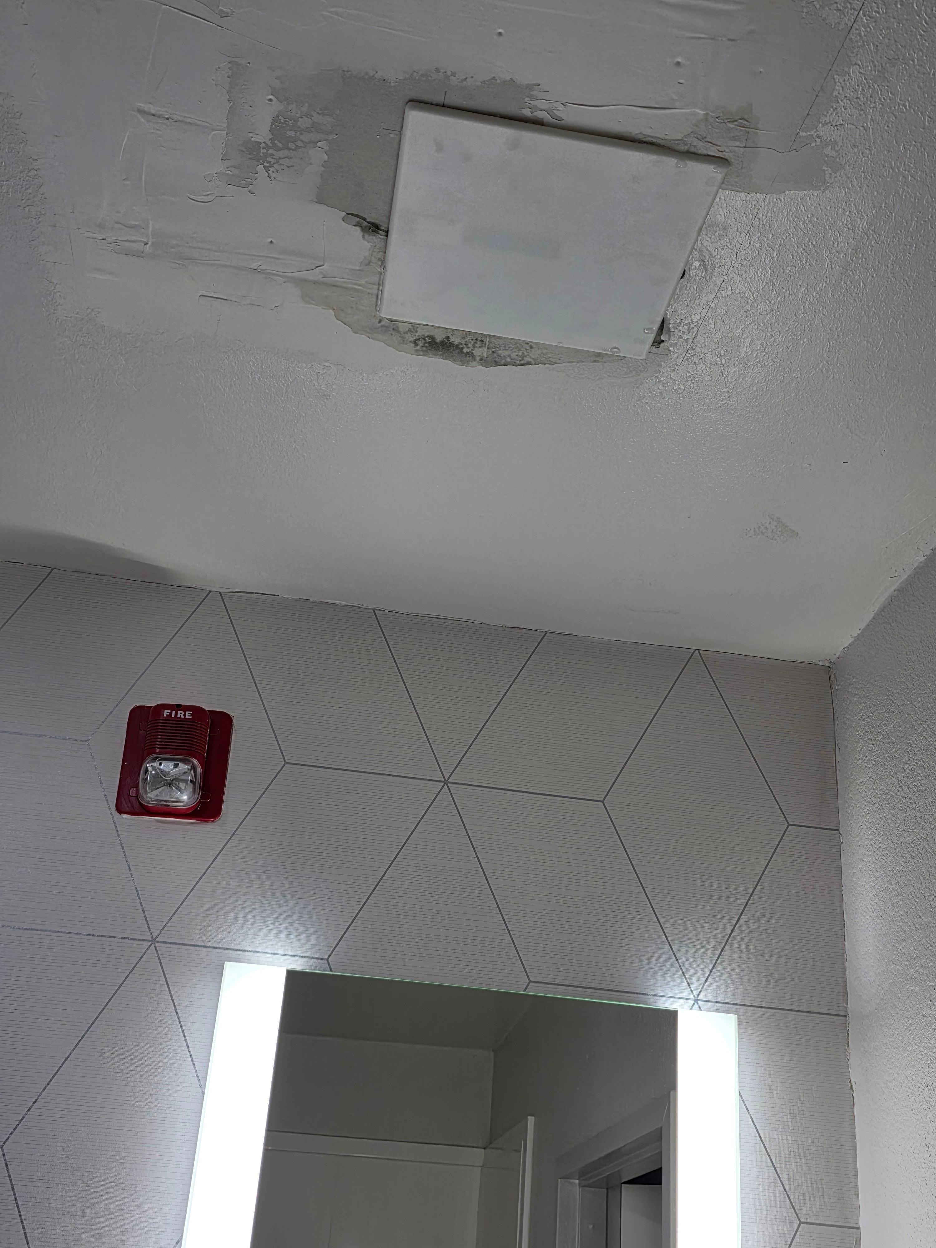 The failed ceiling patch where the water was flowing down from above us and the towels with trash can to carry and contain the issue.