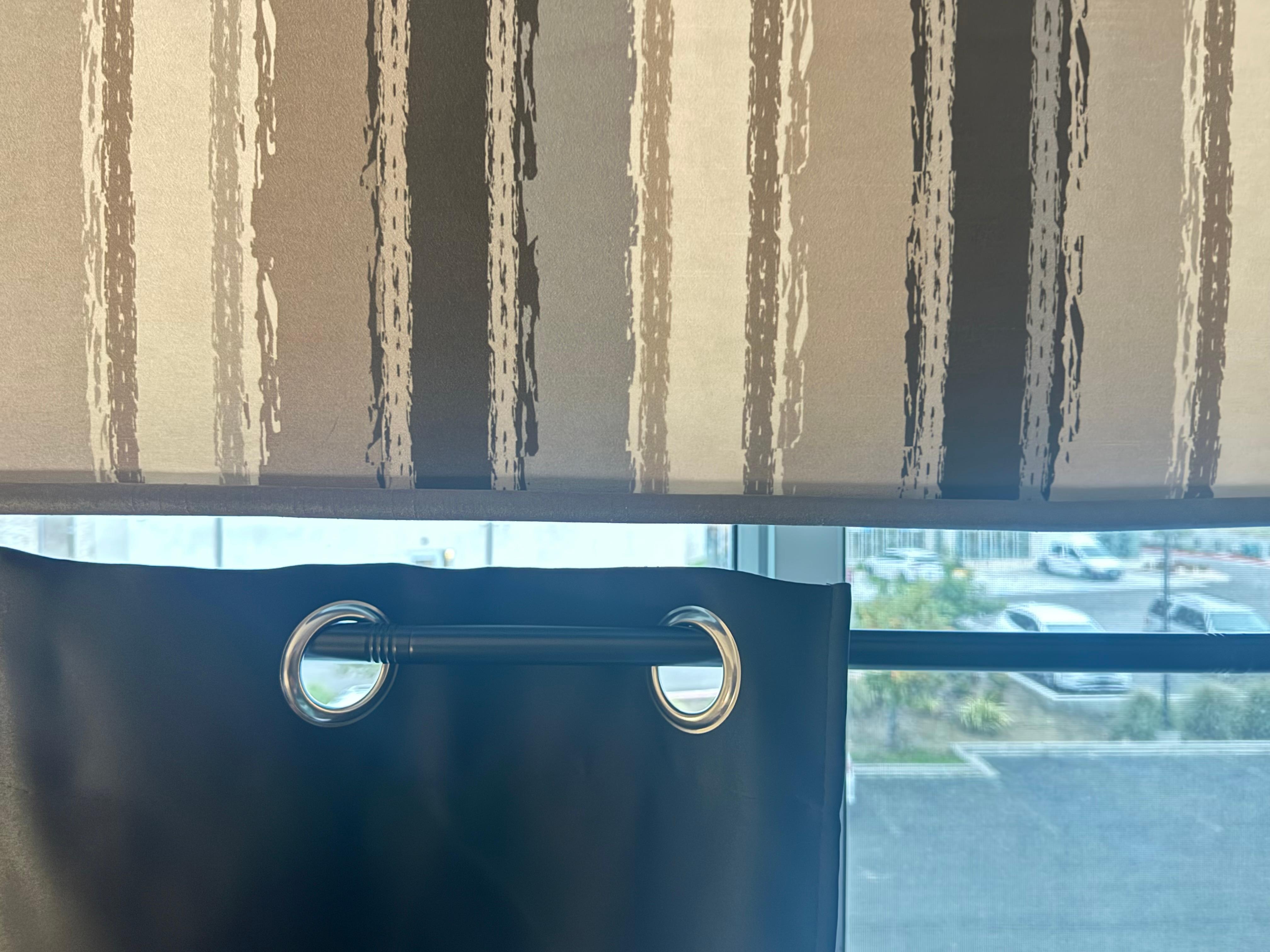 Blackout curtain was barely hanging on and allowed for others at the adjacent hotel to see in and flashing lights 