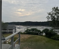 View of front porch, lawn, and water.