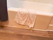 The edges around the bathtub were damaged and in very poor condition.