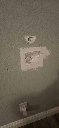 Hole in wall behind front door caused by doorknob striking wall.