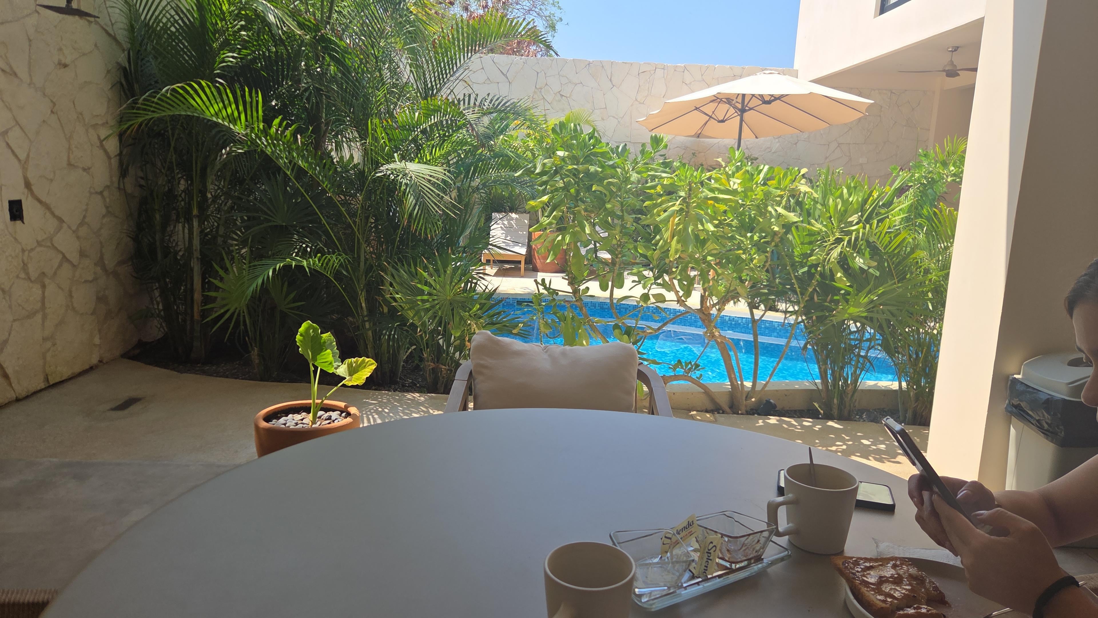 Mesas y sillas cómodas a un costado de la alberca