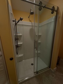 Spacious shower with multiple shower heads.