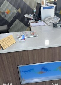 Multiple personal computers, phone and makeup all over the main desk to check in (not in the office)