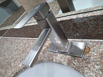 Poorly fitted faucet- holes from the previous fixture still showing- poorly filled in