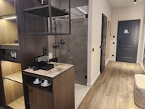 The shower/sink was "open" (right there on the other side of the divider) but the toilet was in it's own room.