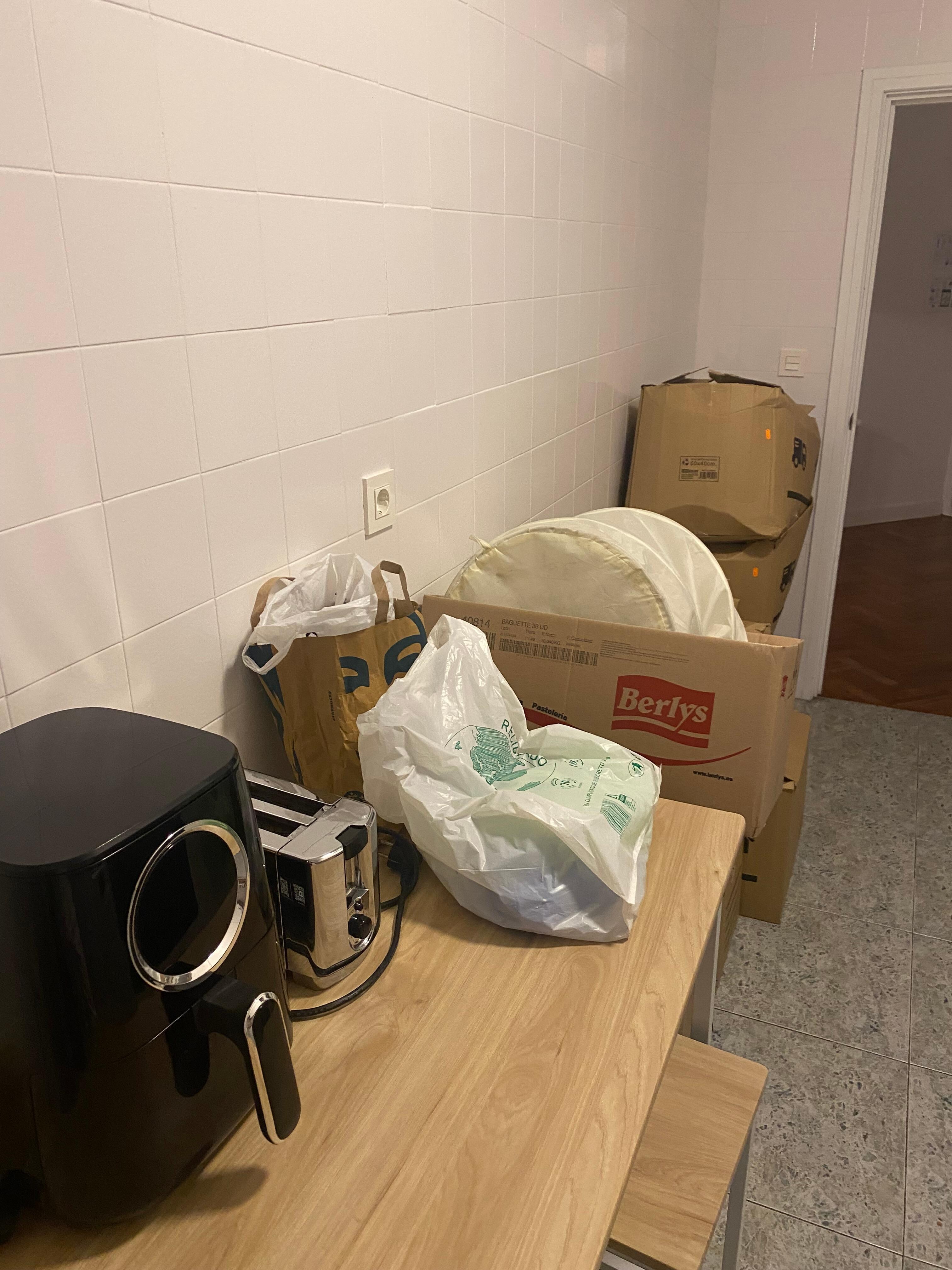 Boxes of someone's stuff piled in the kitchen.