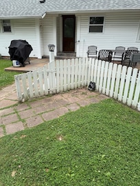 Jug of oil sitting in corner of fence