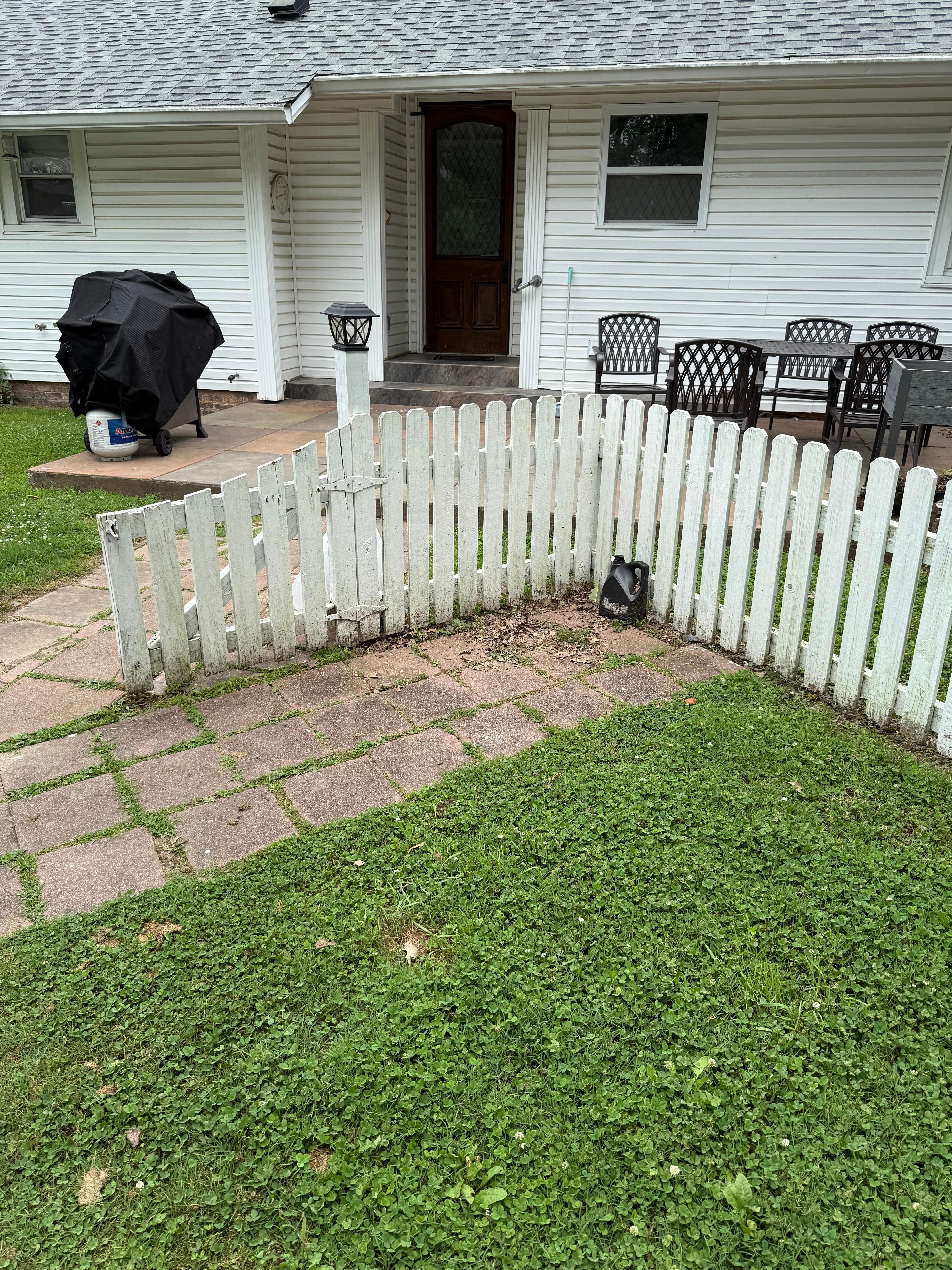 Jug of oil sitting in corner of fence