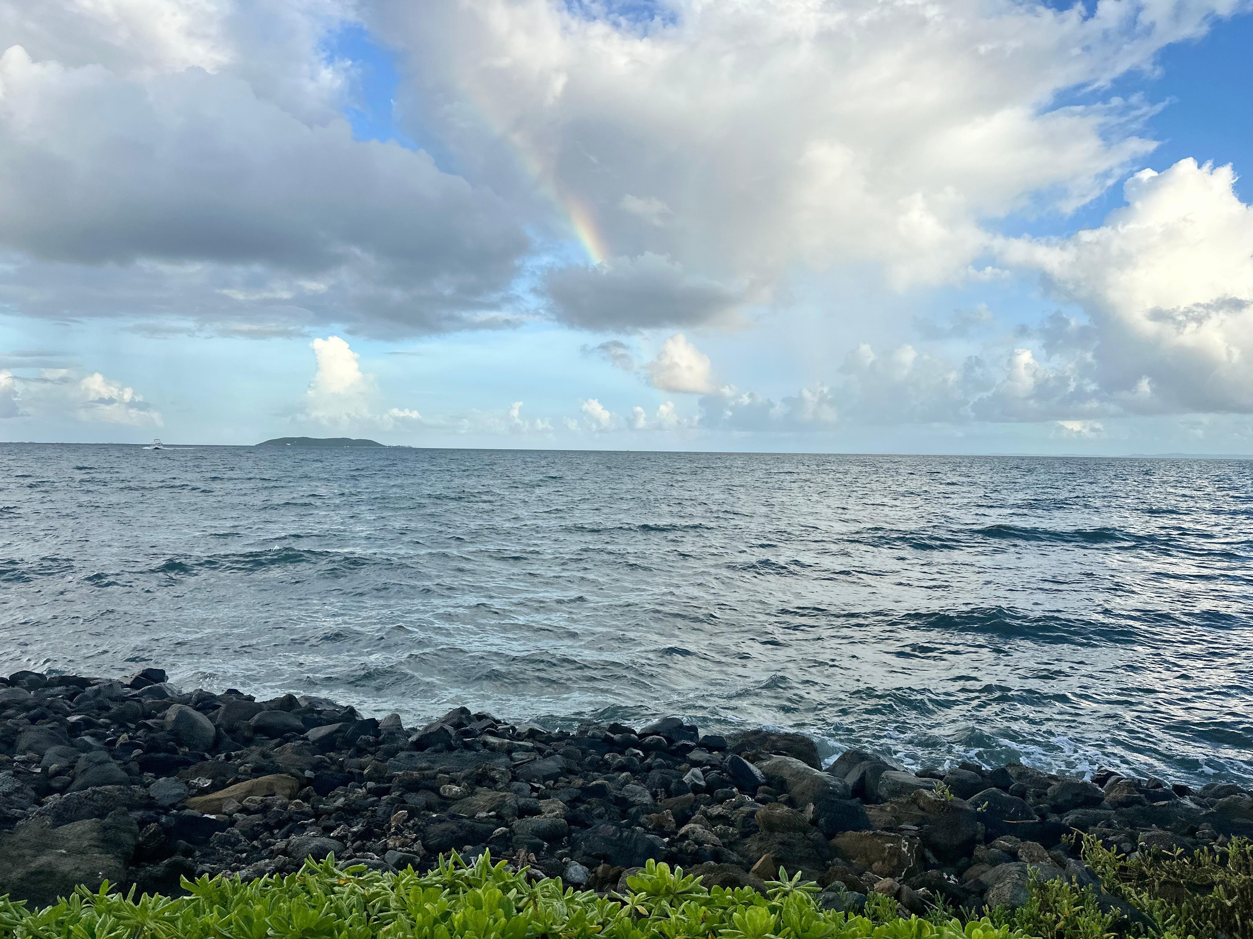 View from the infinity pool in the waterpark of the ocean with a rainbow 