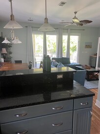 Open concept kitchen making dinner while they watch tv