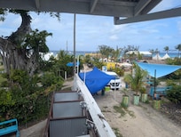 View from the front door to the property: the beach is straight ahead and food is just behind the blue awning.