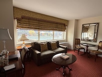 Living room with large screen tv and table for 2. Bar area with little refrigerator and coffeemaker.