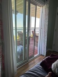 View from room with queen bed looking out onto covered deck
