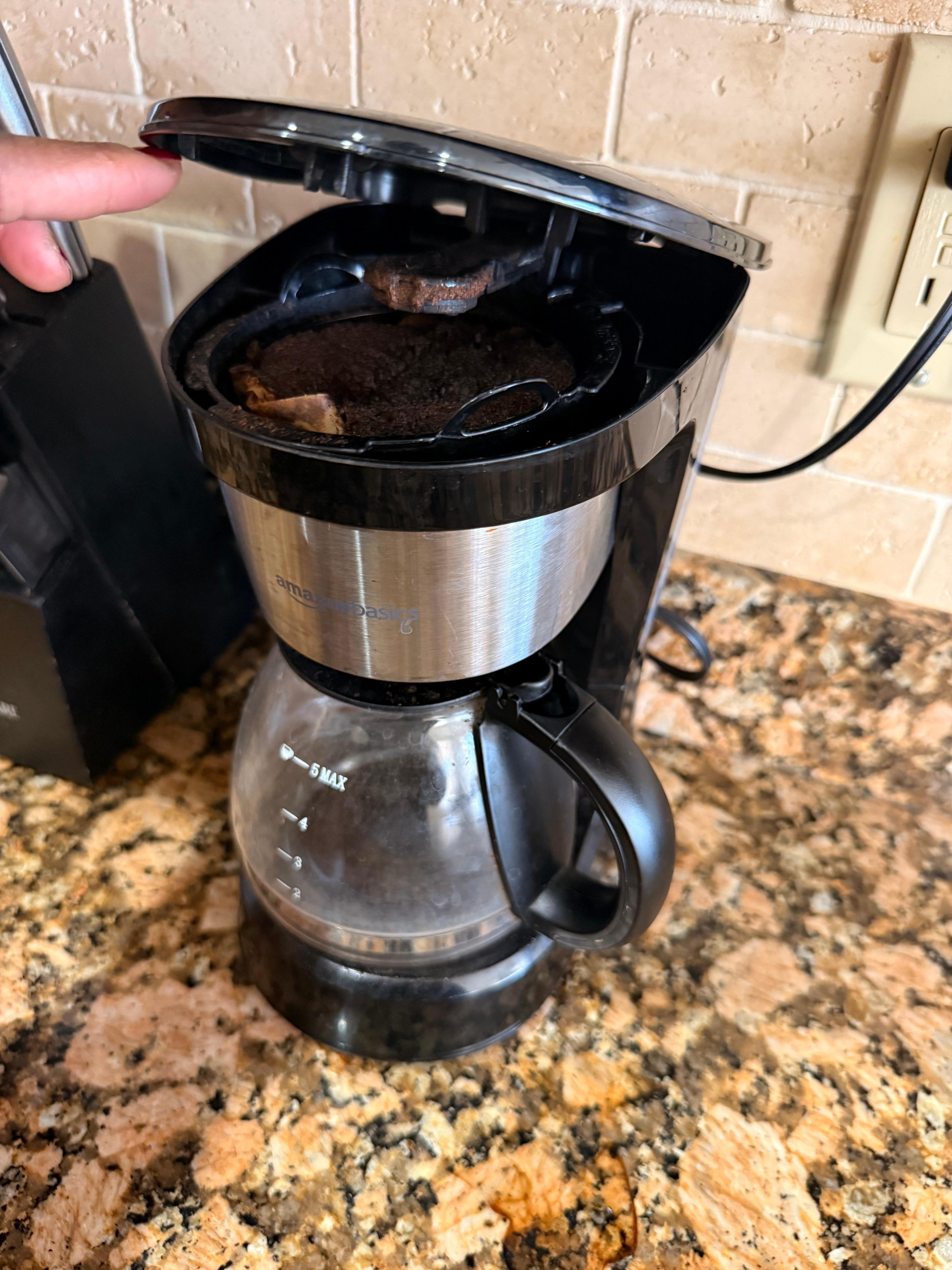 Dirty coffee pot filled with used coffee grounds and they were dirty pots and silverware and we clean dishes