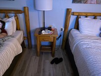 One small end table for 2 queen beds. Head boards not attached to bed, just leaning on wall. Beds easily push away from headboard.