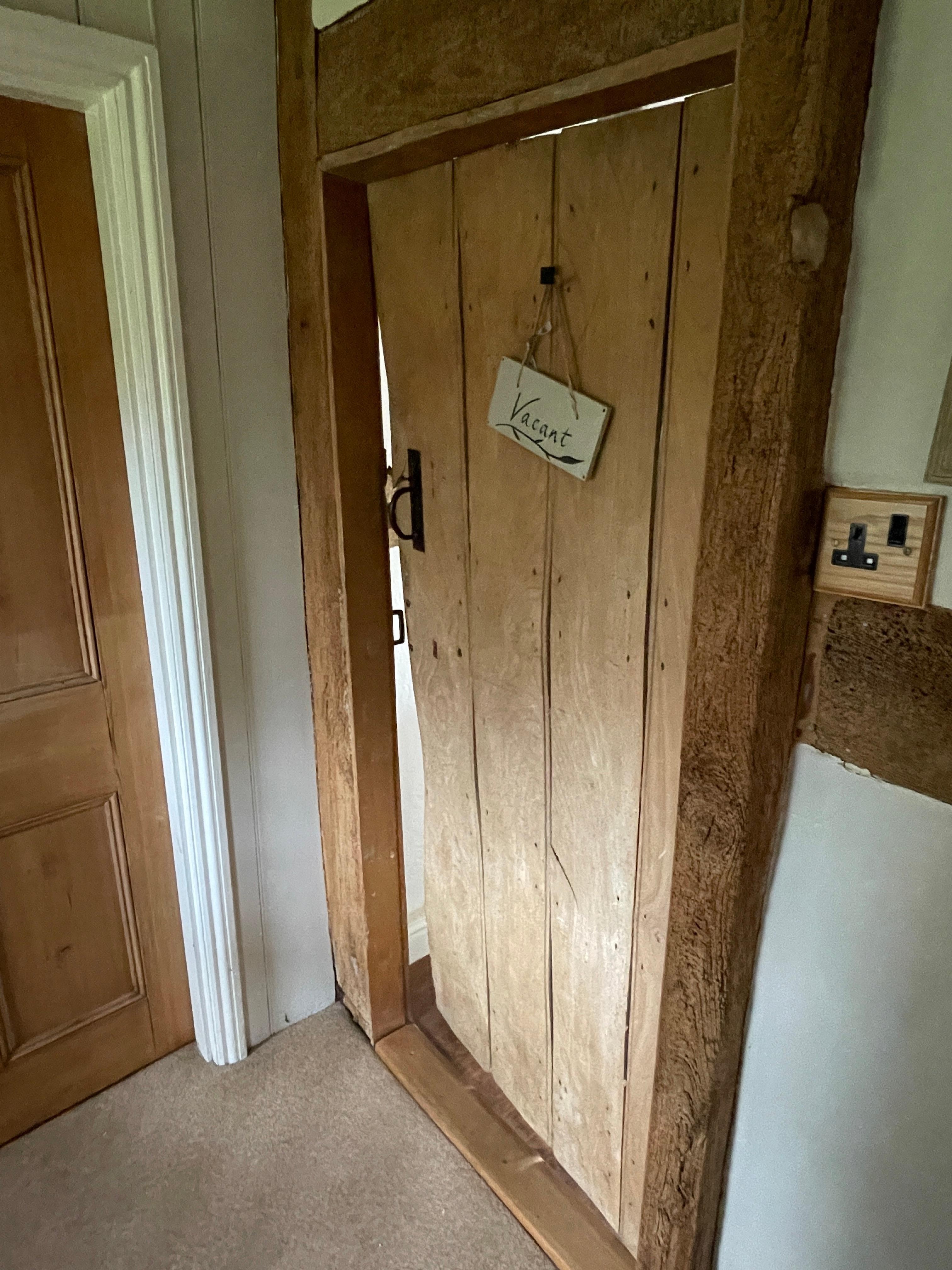 Bathroom door secured with a hook; this photo shows the door fully closed.