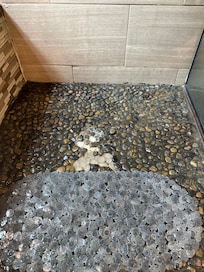 Shower floor rocks coming loose (piled in shower corner).