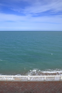 Visuale dalla finestra della camera guardando in basso, c'è la terrazza dell'hotel e subito sotto la spiaggia