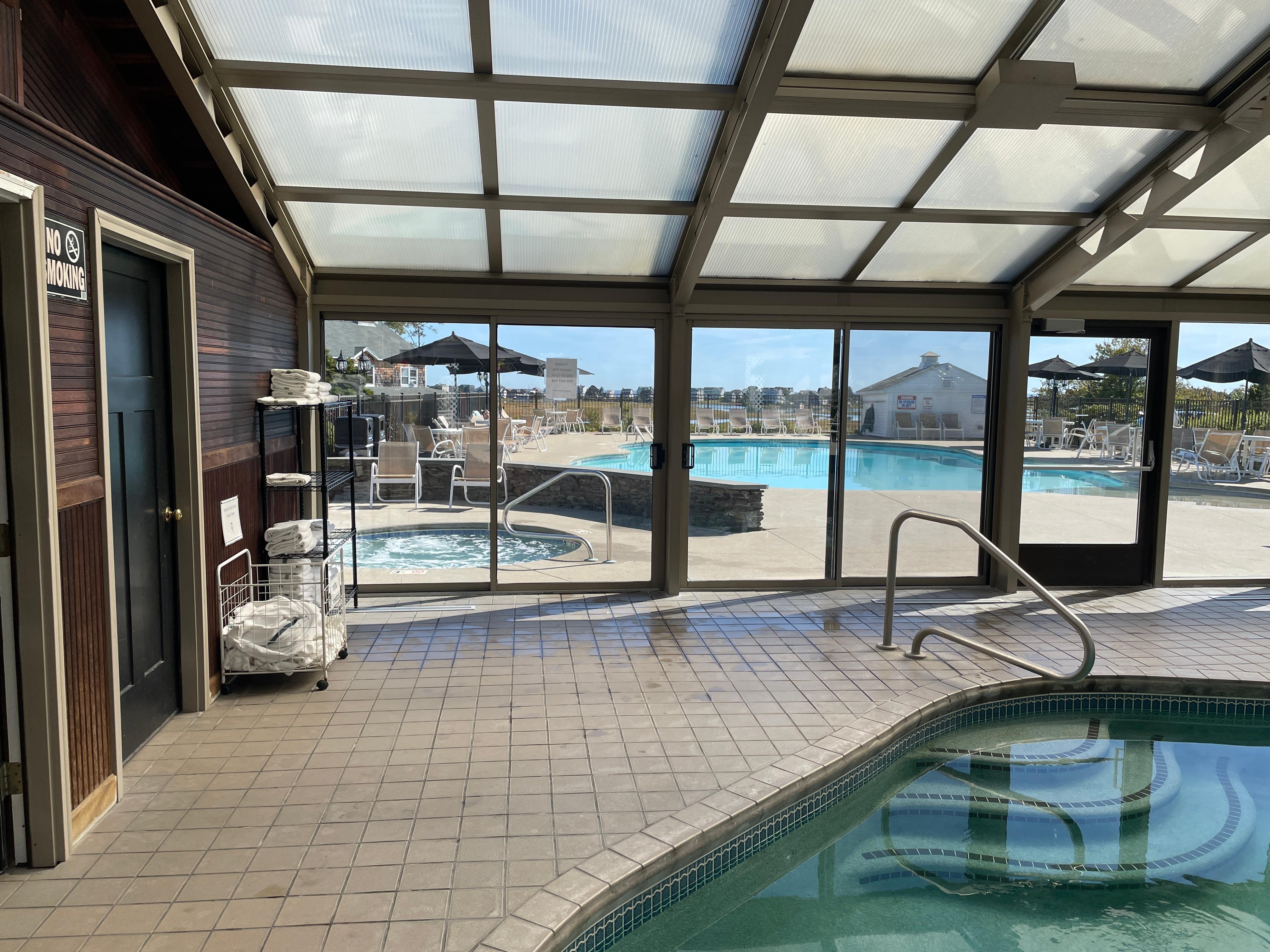 The indoor pool facing the outdoor hot tub and pool