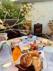 Frukost serverad i en frodig trädgård i en glaspaviljong.