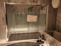 To enter the shower you either enter on the side of the shower head or step over this table. The glass door slides open somewhat further but you're still stepping over the table