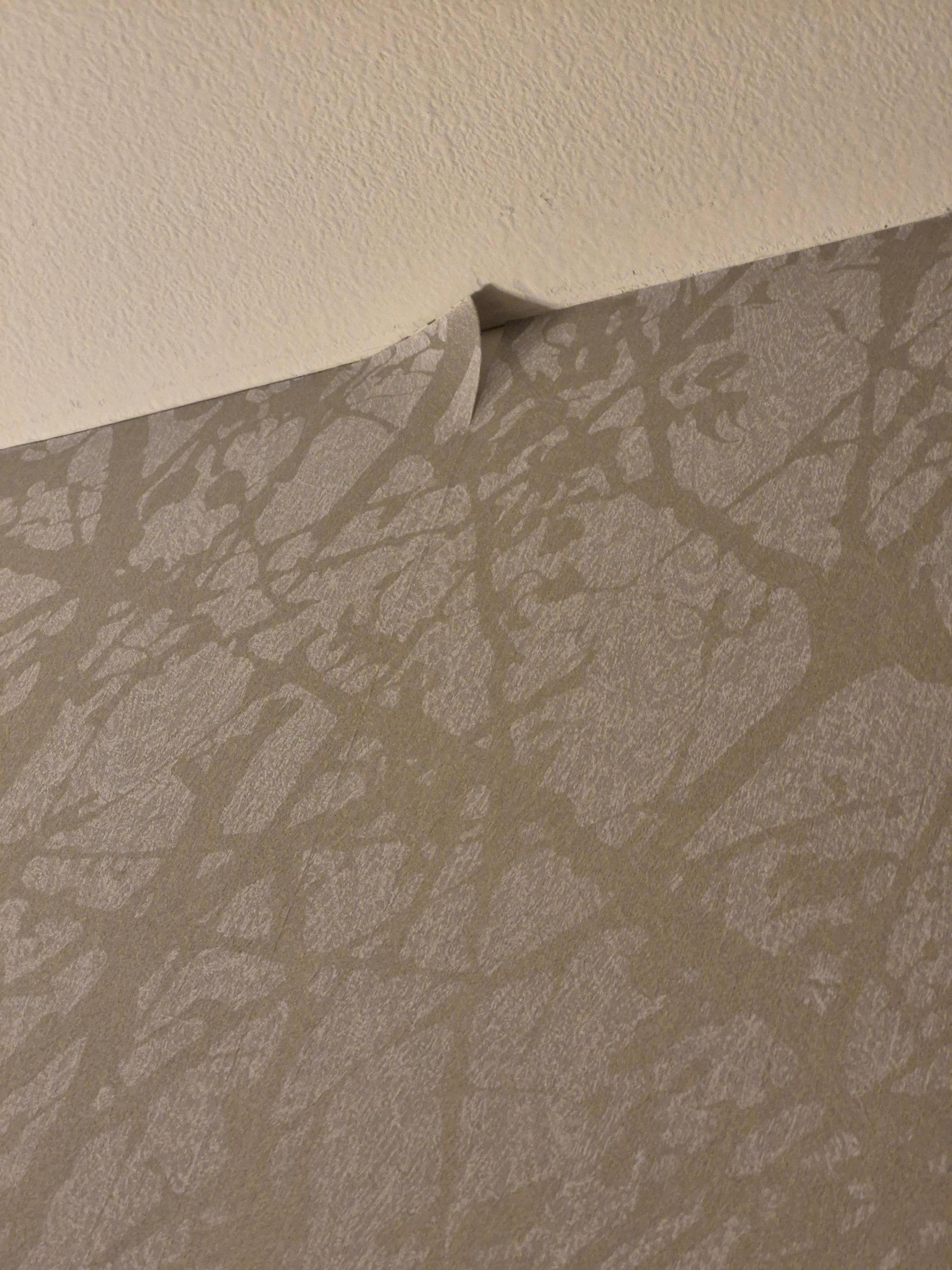 Wallpaper peeling above the bed
