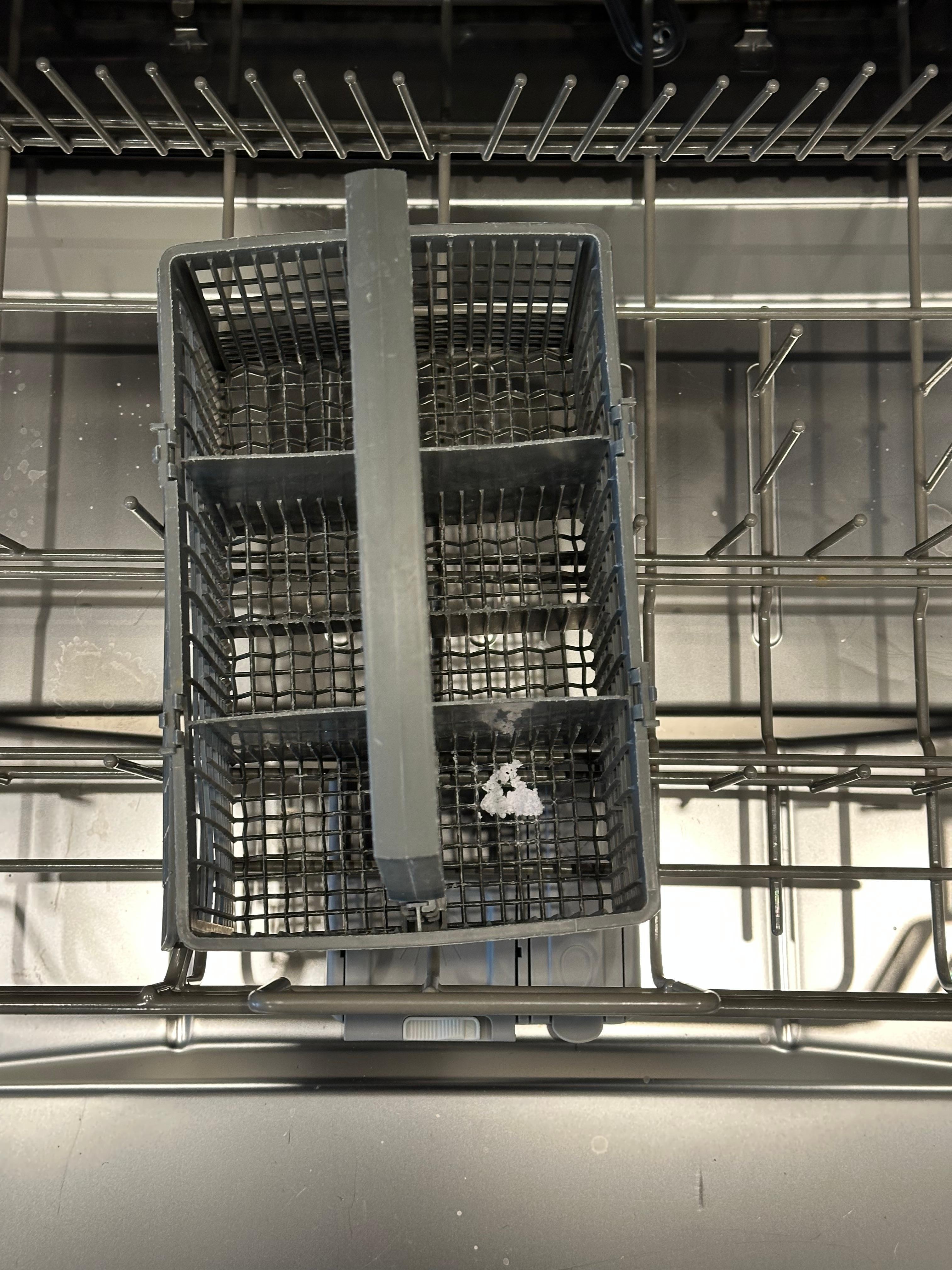 Silverware tray in dishwasher with old debris greeted me.